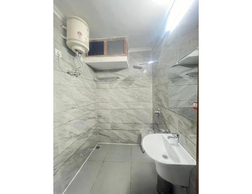a white bathroom with a sink and a toilet at Hotel Majestic in Chandīgarh