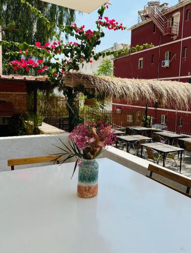 a vase filled with flowers sitting on top of a table at Jericho rooms in Sarandë