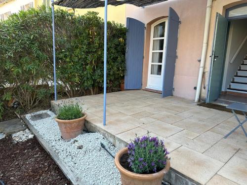 une terrasse avec deux plantes en pot devant une maison dans l'établissement Attractive Townhouse - Golf de Fregate, à Saint-Cyr-sur-Mer