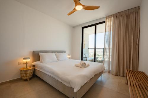 a bedroom with a bed and a large window at Maui Apartment-By Harim in Eilat