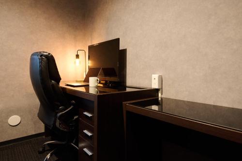 an office with a desk with a computer and a chair at Residence Hotel Stripe Sapporo in Sapporo