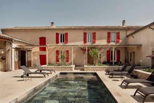 a house with a swimming pool in front of a house at La ferme du 645 in Entraigues-sur-la-Sorgue