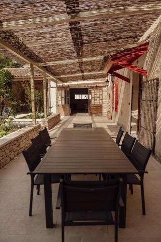 une table et des chaises en bois sur une terrasse dans l'établissement La ferme du 645, à Entraigues-sur-la-Sorgue