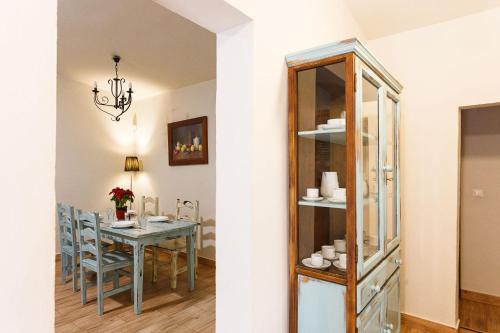 a dining room with a table and a chandelier at Apiedesierra - Caserio del Colmenar in Huétor Santillán
