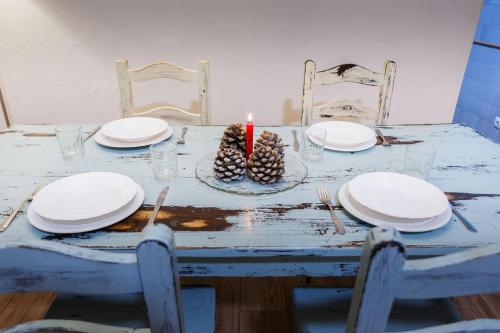 a table with plates and a candle on it at Apiedesierra - Caserio del Colmenar in Huétor Santillán