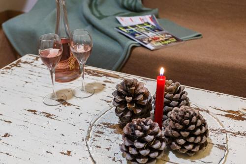 two glasses of wine and two candles on a table at Apiedesierra - Caserio del Colmenar in Huétor Santillán