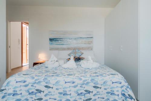 a bedroom with a bed with a blue and white comforter at Home BellaVista, a pochi passi dalla spiaggia in Favignana