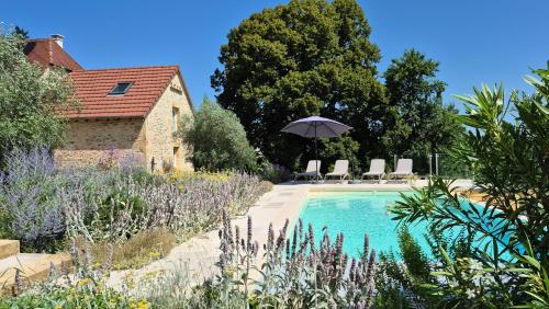 una piscina con sedie e ombrellone in giardino di Clos Lamonzie a Sarlat-la-Canéda