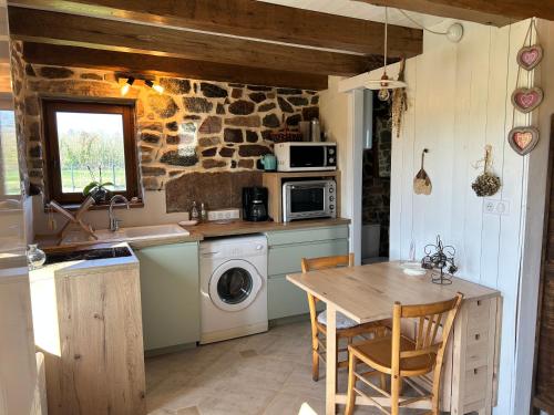 - une cuisine avec une table, un évier et un lave-linge dans l'établissement 206 - Charmante maison bretonne idéale pour deux., à Plurien