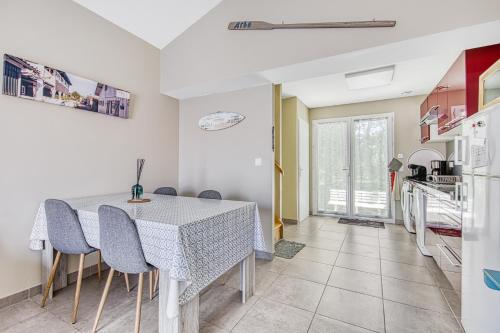 une cuisine et une salle à manger avec une table et des chaises dans l'établissement Escapades Marines Classée 3 Étoiles, à Arès