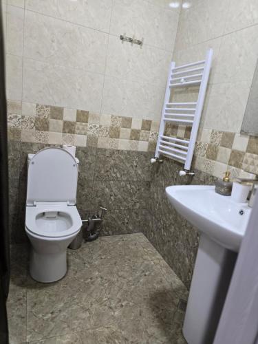 a bathroom with a toilet and a sink at Batumi Bliss Panoramic Views in Batumi