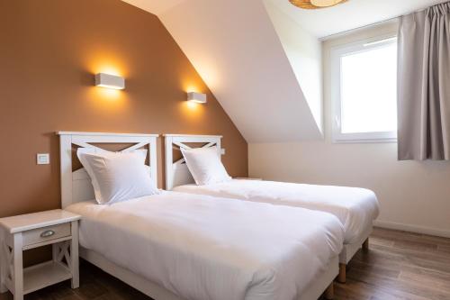 two beds sitting next to each other in a room at Résidence Odalys Les Villas de la Baie in Le Crotoy