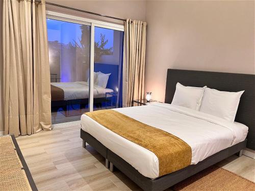 Un dormitorio con una cama grande y un balcón. en DOMAINE LES ATELIERS et SPA, en Antananarivo