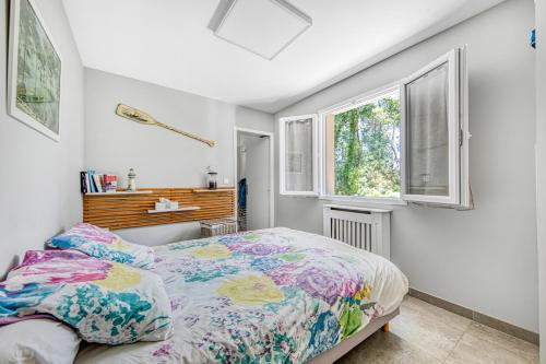 una camera da letto con un letto e due finestre di Escapades Marines Classée 3 Étoiles ad Arès