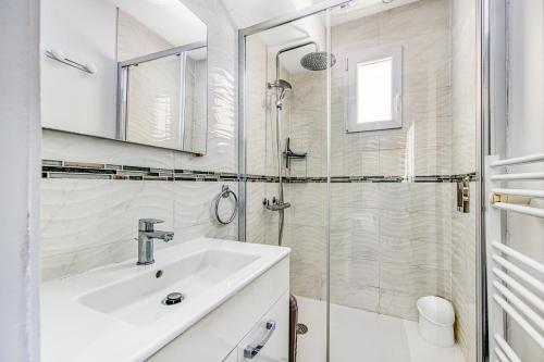 un bagno bianco con lavandino e doccia di Escapades Marines Classée 3 Étoiles ad Arès