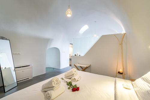 Un dormitorio con una cama con toallas. en Veneston Suites, en Fira