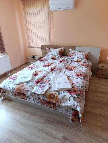 a bed in a bedroom with two books on it at Винарна-Славовица in Kalugerovo