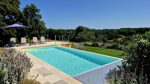 - une piscine dans une cour avec des chaises et un parasol dans l'établissement Clos Lamonzie, à Sarlat-la-Canéda
