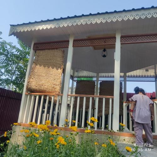 a man standing in front of a house at Wahab's INN - riverside cottage in Srinagar
