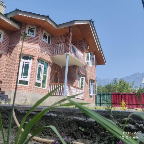 a brick house with a porch and a balcony at Wahab's INN - riverside cottage in Srinagar