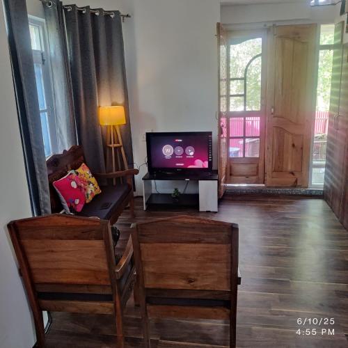 a living room with a flat screen tv and a couch at Wahab's INN - riverside cottage in Srinagar