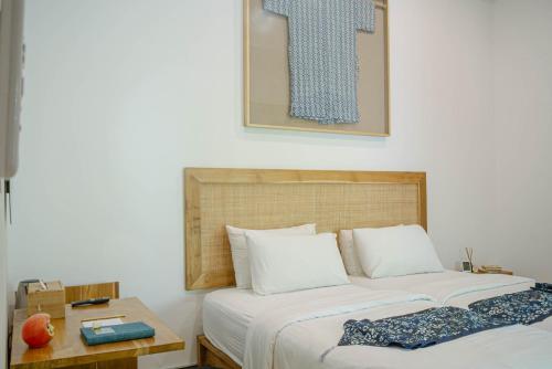 a bedroom with two beds and a table at MIMOYA Guest House, Sanur in Sanur