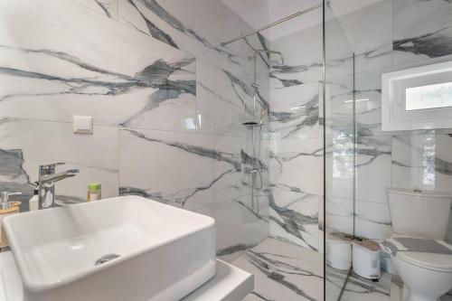 a white bathroom with a sink and a shower at Ionian Home in Exanthia