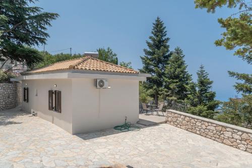 a small white house with a stone wall at Ionian Home in Exanthia