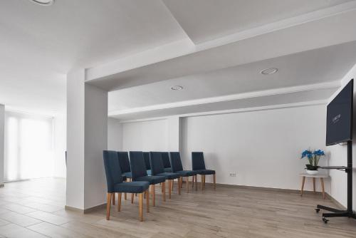 a waiting room with blue chairs and a flat screen tv at Eurostars Puerto de Ibiza in Ibiza Town
