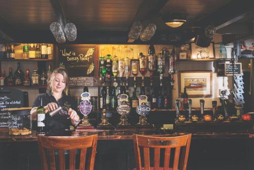 a woman sitting at a bar in a pub at The Ship Inn in Mousehole