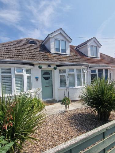 a white house with a green door and windows at Beach house Mablethorpe Stylish Spacious, 2 bedrooms sleeps 6 200m to beach in Mablethorpe