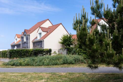a white house with a red roof at Résidence Odalys Les Villas de la Baie in Le Crotoy