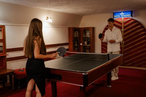 a man and a woman playing a game of ping pong at Hotel Korona Wellness, Rendezvény és Borszálloda in Eger
