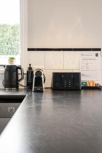 a kitchen with a counter top with a toaster and a appliance at Summery 4BR Home by Mel Airport, CBD & Watergardens in Sydenham