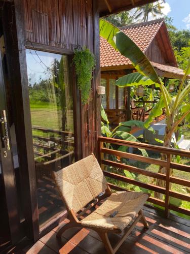 a chair on the porch of a house at Pondok Punaga in Jasri