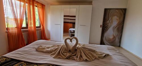 a couple of swans sitting on top of a bed at Ferienwohnung Schwarzer Kater in Wiesenbronn