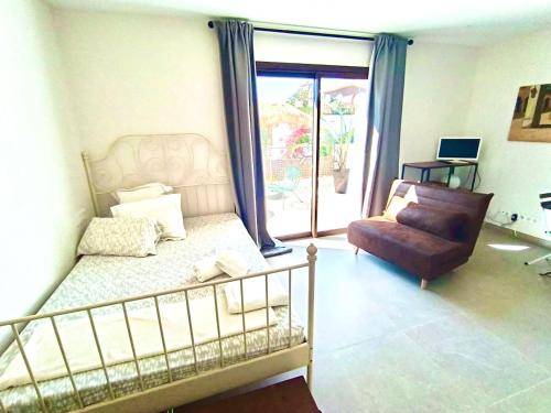 a bedroom with a bed and a chair and a window at Oceanfront apartment in Premiá de Mar