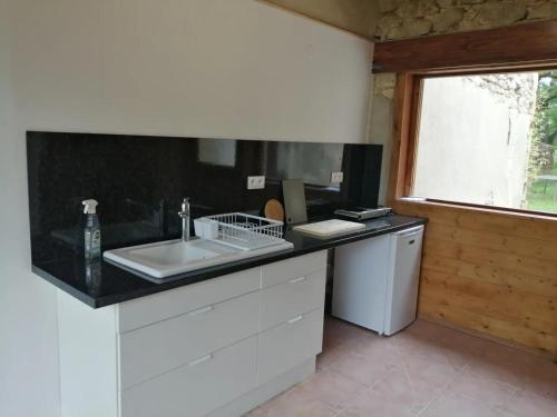 a kitchen with a white sink and a window at La Roulotte Authentique in Grignan