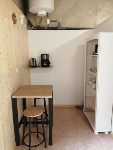 une table et deux tabourets dans une petite pièce dans l'établissement La Roulotte Authentique, à Grignan