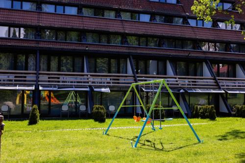 a swing set in the grass in front of a building at "Park Hotel Ela" in Borovets