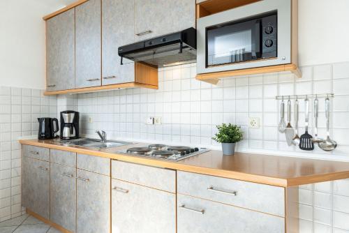 een keuken met een spoelbak en een magnetron bij Dampfer 1 Westwind in Laboe
