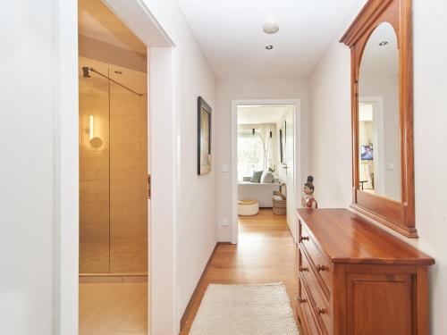 a bathroom with a walk in shower and a wooden dresser at Techts Apartmenthaus in Timmendorfer Strand