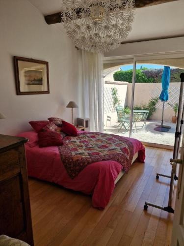 une chambre avec un grand lit et un lustre dans l'établissement Villa avec jacuzzi au cœur de la Provence !, à Monteux