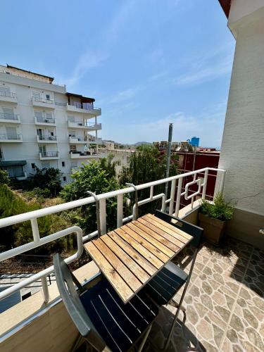 a wooden table and a chair on a balcony at Jericho rooms in Sarandë