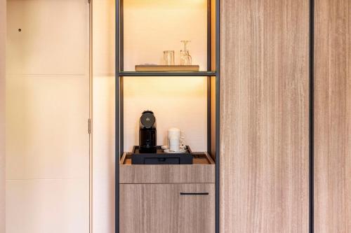 a room with a shelf with a coffee maker on it at NH Amsterdam Leidseplein in Amsterdam