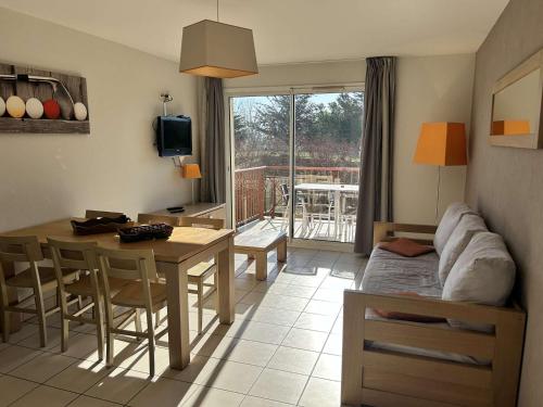 un salon avec une table et une salle à manger dans l'établissement 100 - Appart duplex 6p avec piscine collective., à Fréhel