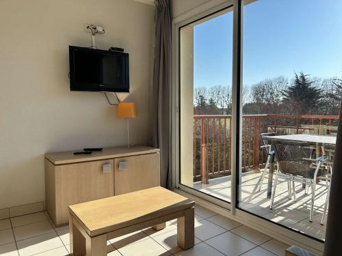 Il comprend un salon doté d'une télévision et d'un balcon. dans l'établissement 100 - Appart duplex 6p avec piscine collective., à Fréhel