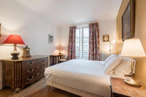 une chambre avec un lit, une commode et une fenêtre dans l'établissement Veeve - The Seaferer, à Paris