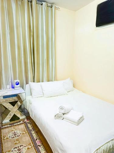 a small bedroom with a white bed and a window at Ajman Friends Downtown Apartment Fully Yours Two Rooms and Kitchen for 3 People in Ajman 