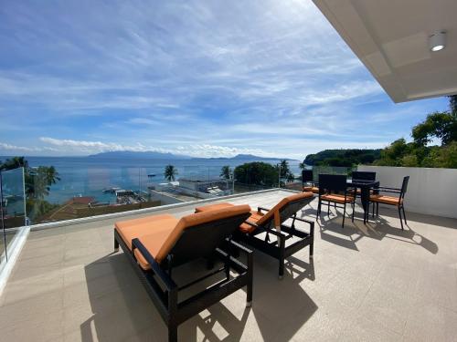 a patio with chairs and tables on a balcony at Lalaguna Villas Luxury Dive Resort and Spa in Puerto Galera